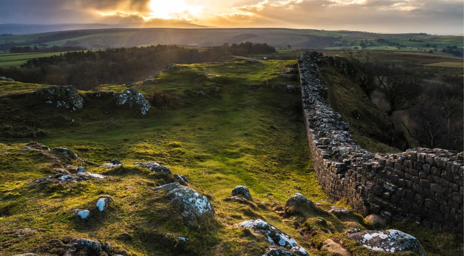 Hadrian's Wall climbing the Whin Sill crags at sunrise above Northumberland moorland