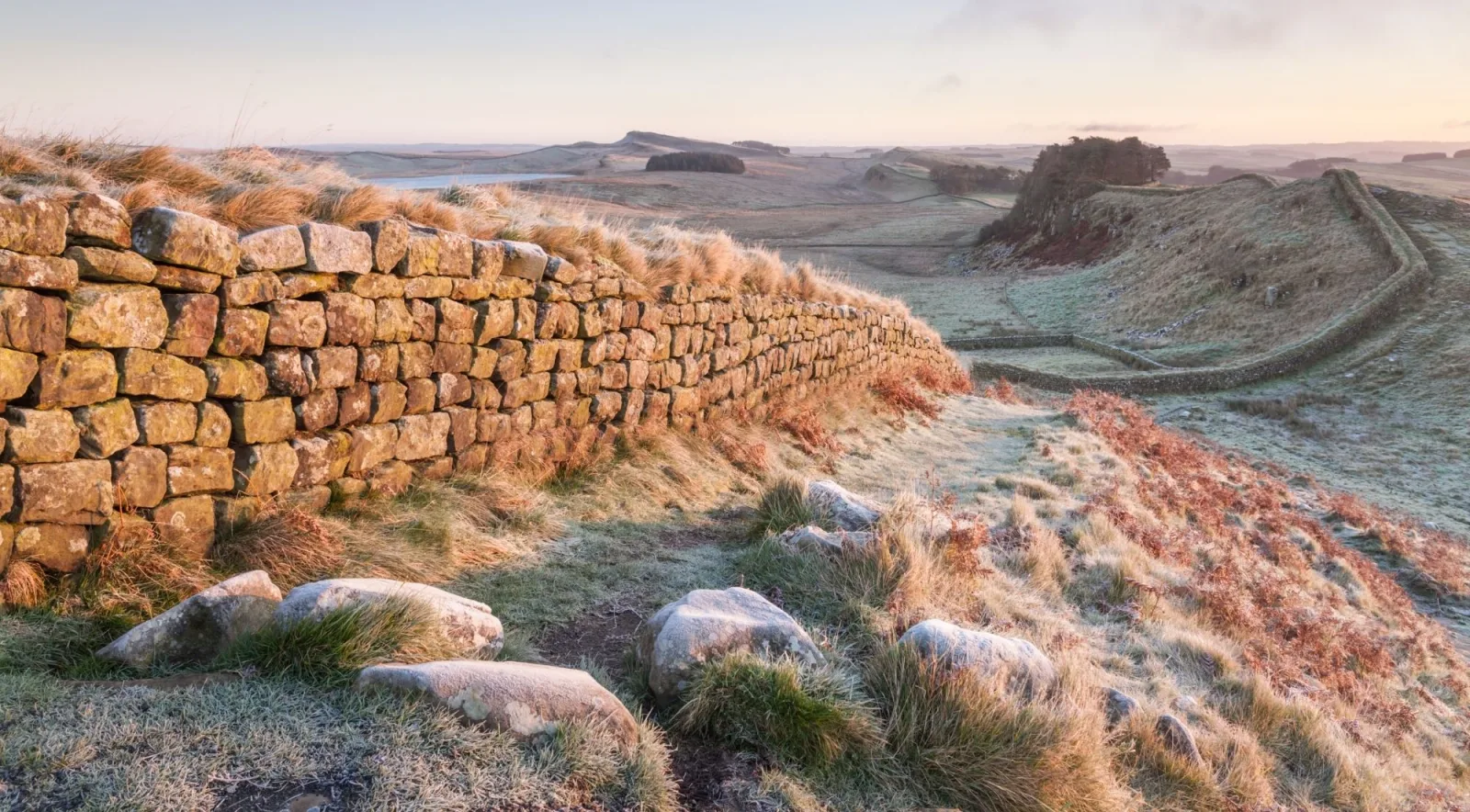 Frost on the stones of Hadrian's Wall at first light, with the crags receding into the distance